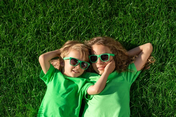 Mutlu Çocuklar Yeşil Çimlerin Üzerinde Yatıyor Baharın Bahçesinde Komik Çocuklar — Stok fotoğraf