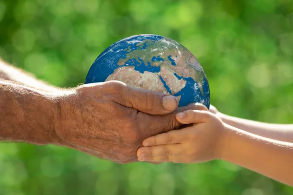 Familie Houdt Planeet Handen Tegen Groene Wazige Achtergrond Zomervakantie Concept — Stockfoto