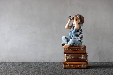 Mutlu çocuk dışarıda oynuyor. Gülümseyen çocuk yaz tatili ve seyahat hayali kuruyor. Hayal gücü ve özgürlük kavramı