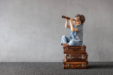 Mutlu çocuk dışarıda oynuyor. Gülümseyen çocuk yaz tatili ve seyahat hayali kuruyor. Hayal gücü ve özgürlük kavramı