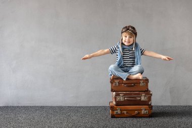 Mutlu çocuk dışarıda oynuyor. Gülümseyen çocuk yaz tatili ve seyahat hayali kuruyor. Hayal gücü ve özgürlük kavramı