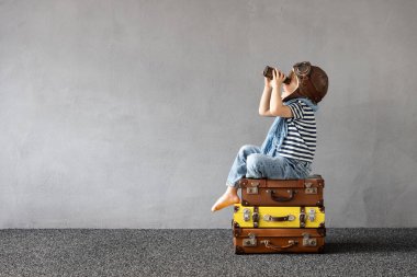 Mutlu çocuk dışarıda oynuyor. Gülümseyen çocuk yaz tatili ve seyahat hayali kuruyor. Hayal gücü ve özgürlük kavramı