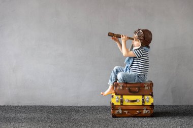 Mutlu çocuk dışarıda oynuyor. Gülümseyen çocuk yaz tatili ve seyahat hayali kuruyor. Hayal gücü ve özgürlük kavramı