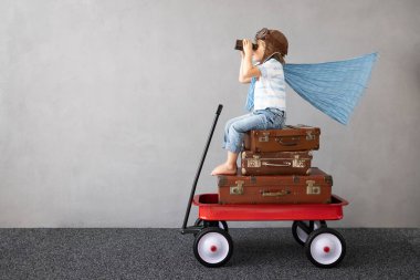 Mutlu çocuk dışarıda oynuyor. Gülümseyen çocuk yaz tatili ve seyahat hayali kuruyor. Hayal gücü ve özgürlük kavramı