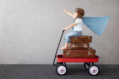 Mutlu çocuk dışarıda oynuyor. Gülümseyen çocuk yaz tatili ve seyahat hayali kuruyor. Hayal gücü ve özgürlük kavramı