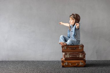 Mutlu çocuk dışarıda oynuyor. Gülümseyen çocuk yaz tatili ve seyahat hayali kuruyor. Hayal gücü ve özgürlük kavramı