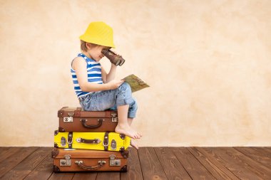 Evde oynayan mutlu çocuk. Gülümseyen çocuk yaz tatili ve seyahat hayali kuruyor. Hayal gücü ve özgürlük kavramı