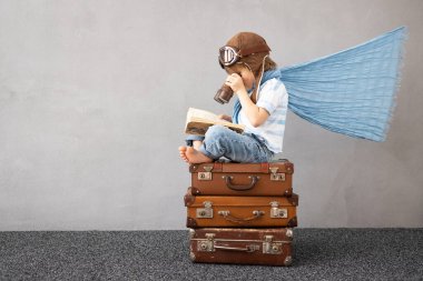 Mutlu çocuk dışarıda oynuyor. Gülümseyen çocuk yaz tatili ve seyahat hayali kuruyor. Hayal gücü ve özgürlük kavramı