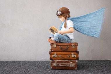 Mutlu çocuk dışarıda oynuyor. Gülümseyen çocuk yaz tatili ve seyahat hayali kuruyor. Hayal gücü ve özgürlük kavramı