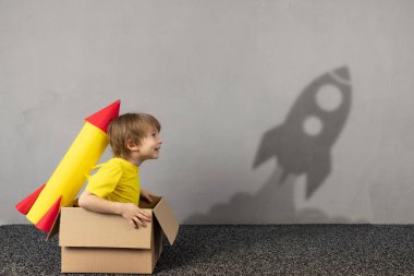 Oyuncak kağıttan roketi olan mutlu çocuk uçmak istiyor. Komik çocuk uzay hakkında rüyalar görüyor. Hayal gücü, özgürlük ve motivasyon kavramı