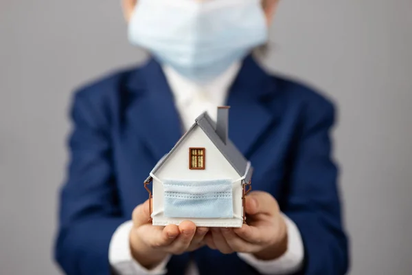 Niño Sosteniendo Casa Modelo Con Máscara Médica Protectora Las Manos —  Fotos de Stock