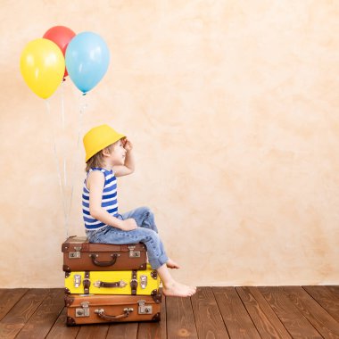 Çocuk gezgin gibi davranıyor. Çocuk evde eğleniyor. Yaz tatili ve seyahat konsepti