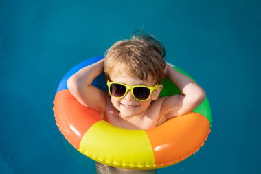 Havuzda yüzen mutlu çocuk. Çocuk yaz tatilinde eğleniyor. Sağlıklı yaşam tarzı kavramı