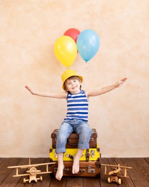 Çocuk gezgin gibi davranıyor. Çocuk evde eğleniyor. Yaz tatili ve seyahat konsepti