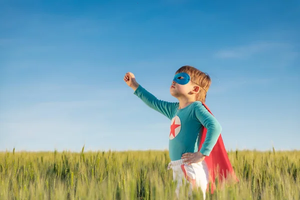 超级英雄的孩子在绿地里玩 超级英雄小子与夏日蓝天背景的对比 自由和儿童的梦想概念 — 图库照片
