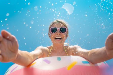 Mutlu bir kadın yaz tatilinde mavi gökyüzü arka planına karşı eğleniyor. Bahar tatili!