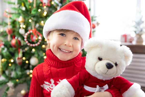 Šťastné Dítě Klobouku Santa Clause Kluk Doma Hraje Medvídkem Portrét — Stock fotografie