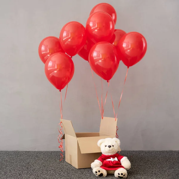 Urso Pelúcia Vestindo Traje Natal Perto Caixa Com Balões Vermelhos — Fotografia de Stock