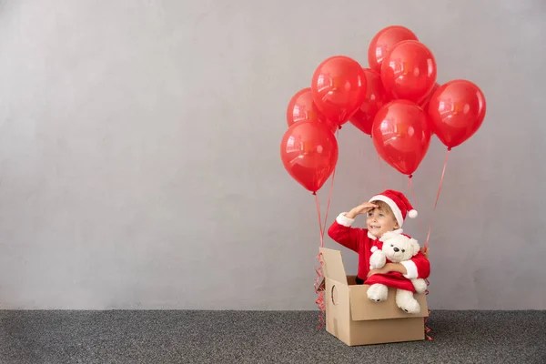 Gelukkig Kind Kerstkostuum Hij Zit Een Doos Met Rode Ballonnen — Stockfoto