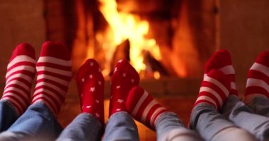 Şöminenin yanındaki Noel çoraplı mutlu aile. Anne, baba ve çocuklar birlikte eğleniyorlar. İnsanlar evde dinleniyor. Kış tatili Xmas ve Yeni Yıl konsepti
