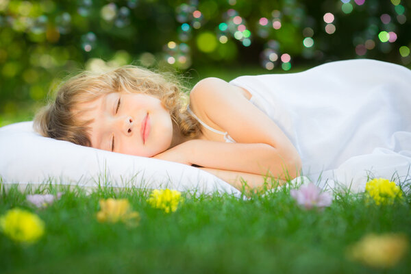 Ребенок спит в весеннем саду
