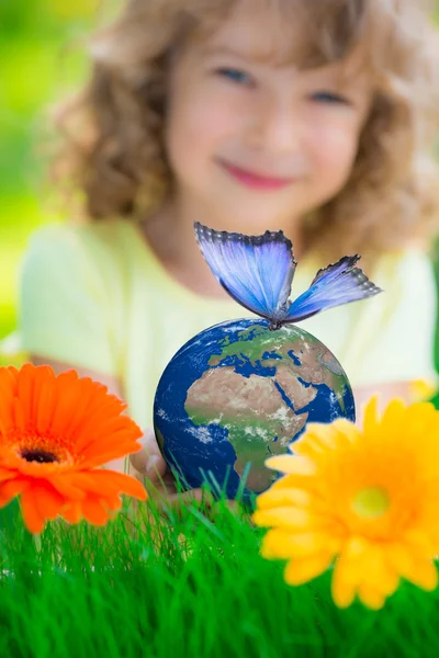 Criança segurando planeta Terra com borboleta azul nas mãos — Fotografia de Stock