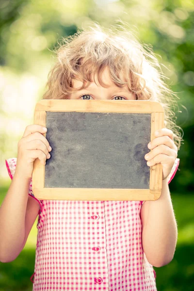 Child holding blackboard — Stock Photo, Image