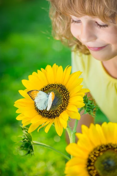 Ребенок с бабочкой и цветами — стоковое фото