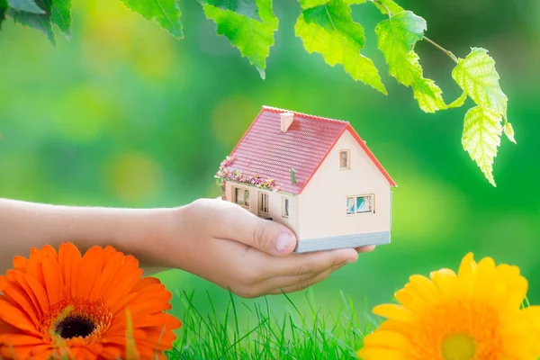 Casa en mano contra la primavera — Foto de Stock