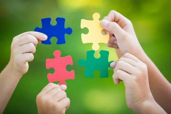 Multicolor puzzles in hands — Stock Photo, Image