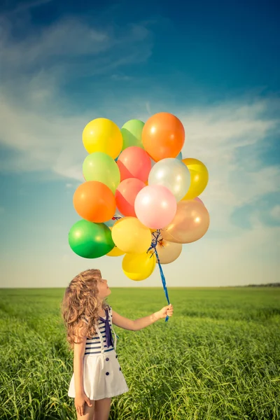 Niño con globos en el campo —  Fotos de Stock