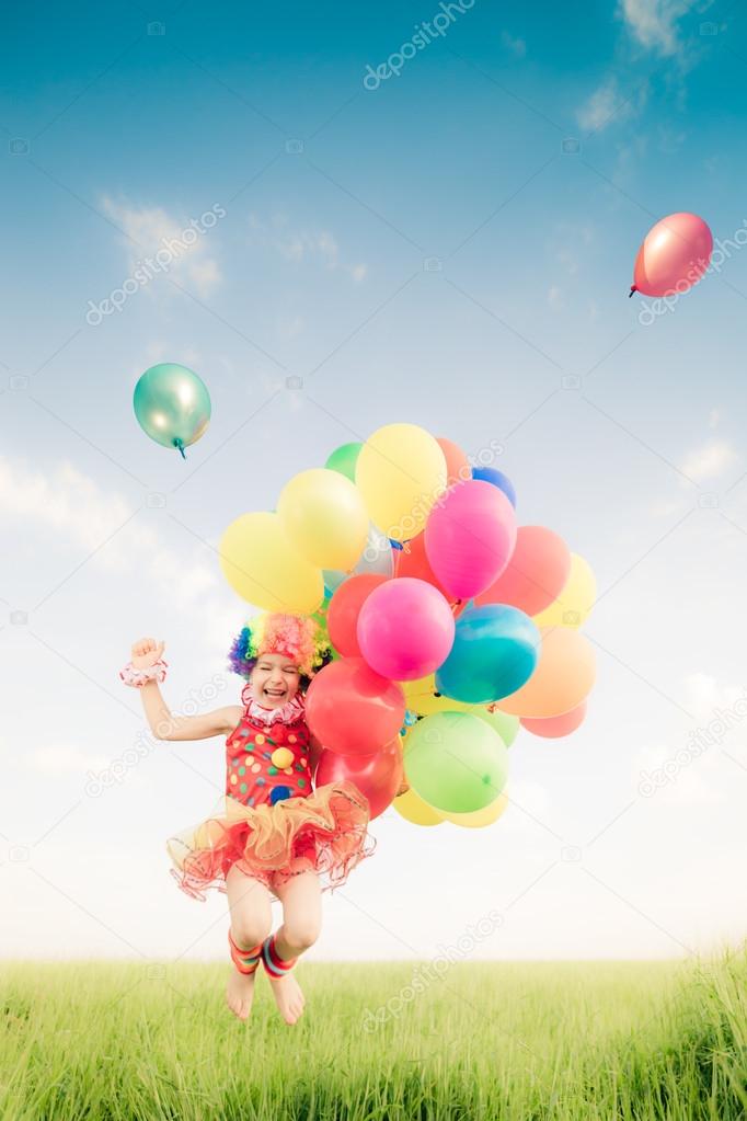 Child jumping with balloons