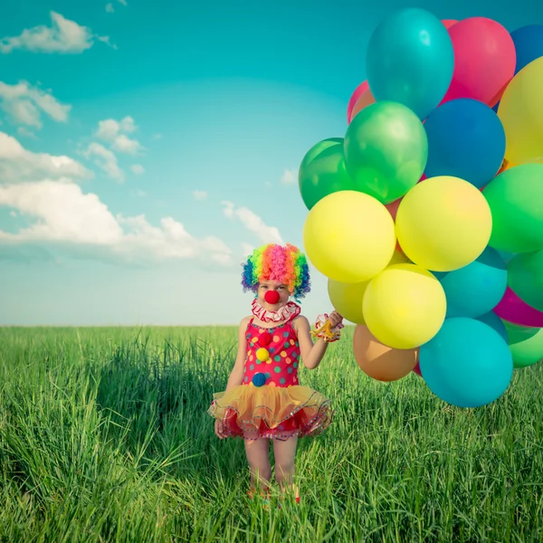 Child with toy balloons in spring field — Stock Photo, Image