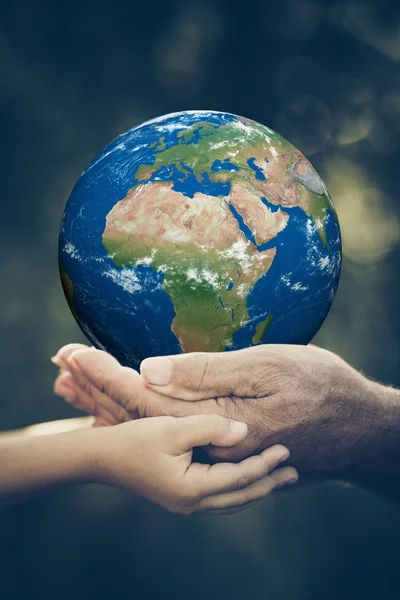 Child and senior holding Earth planet in hands — Stock Photo, Image