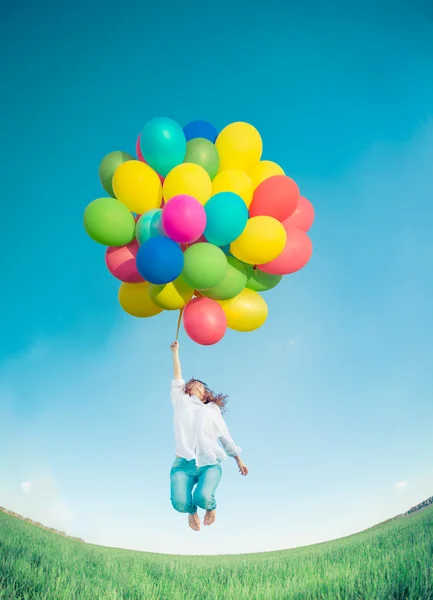 Γυναίκα άλμα με παιχνίδι μπαλόνια στο πεδίο άνοιξη — Φωτογραφία Αρχείου