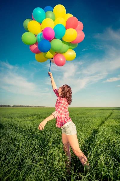 Kobieta z zabawkami balony wiosna pole — Zdjęcie stockowe