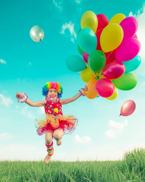 Niño con globos de juguete en campo de primavera —  Fotos de Stock
