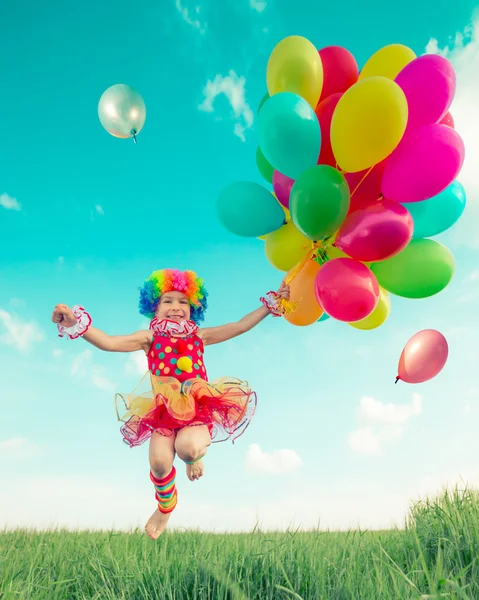 Criança com balões de brinquedo no campo de primavera — Fotografia de Stock