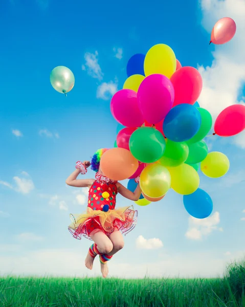 Child with balloons in spring field — Stock Photo, Image