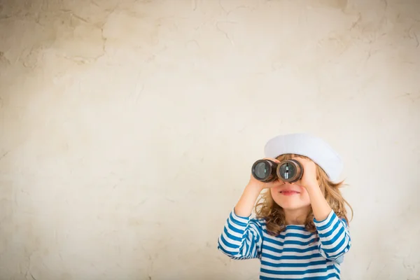 Girl looking through the binoculars — Stock Photo, Image