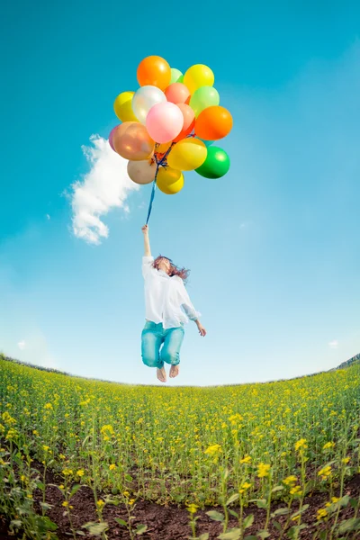 Kvinna med ballonger på våren område — Stockfoto