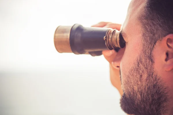 Man looking through the binoculars — Stock Photo, Image