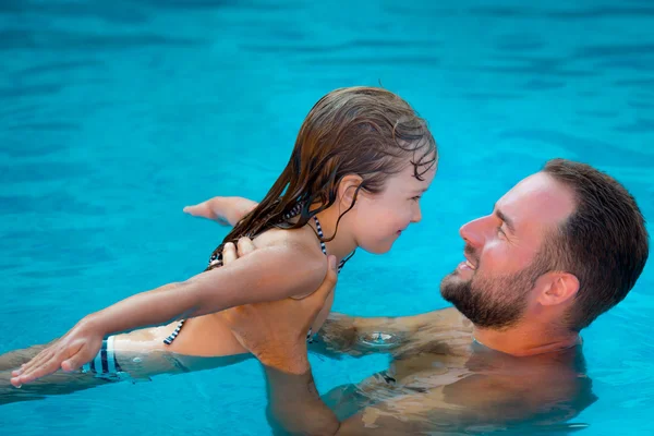 Çocuk ve yüzme havuzunda oynayan baba