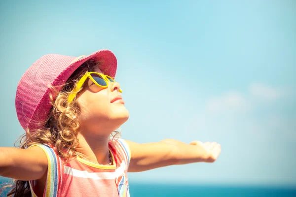 Kind tegen blauwe hemelachtergrond — Stockfoto