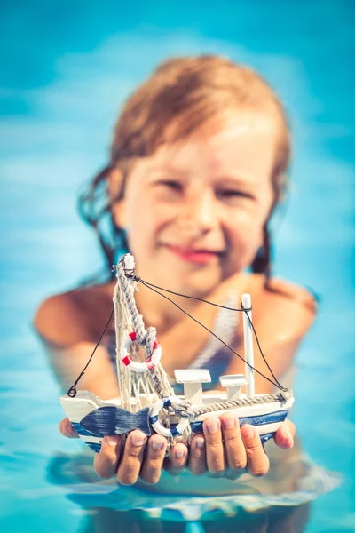 Criança segurando brinquedo barco à vela — Fotografia de Stock