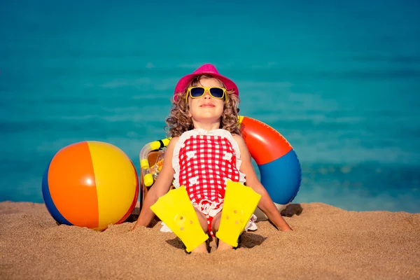 Niño feliz sentado en la playa — Foto de Stock