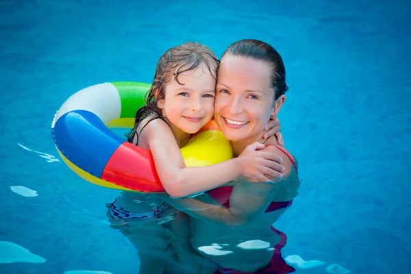Child and woman playing in swimming pool — Stock Photo, Image