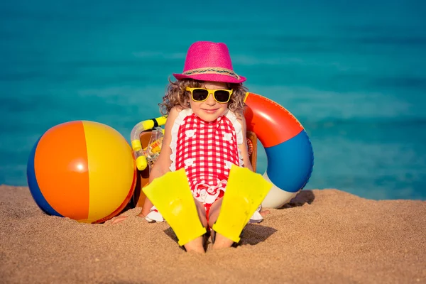 Niño feliz sentado en la playa — Foto de Stock