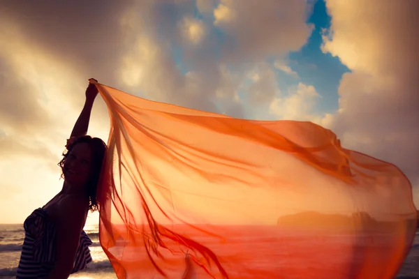 Silhouette einer jungen Frau, die am Strand springt — Stockfoto