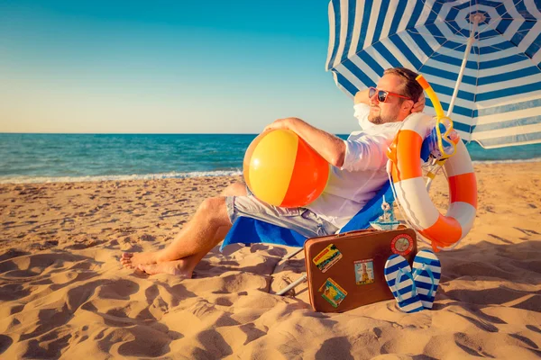 Glad ung man sitter på stranden — Stockfoto